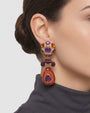 modelo luciendo el pendiente Fleur de Violette en la oreja, apreciando su longitud y contraste cromático sobre la piel.