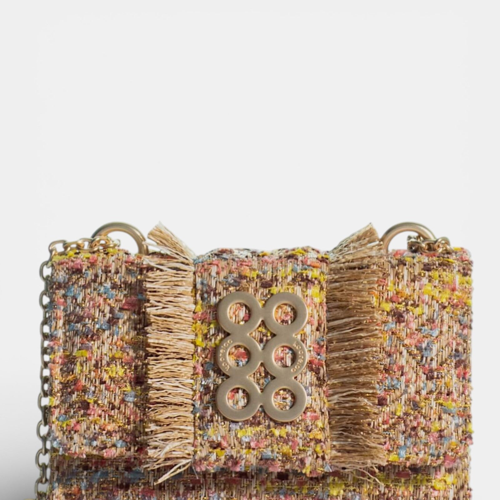 Bolso Kooreloo Lucerne Mini en tweed multicolor amarillo y rosa con bordes deshilachados y logo dorado.