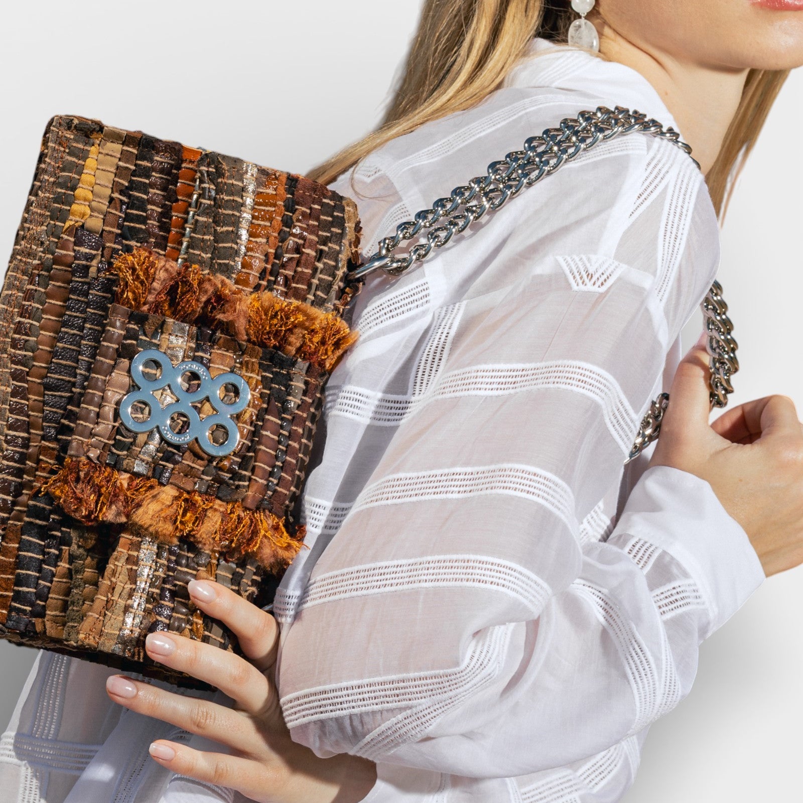 modelo con bolsoVista en ángulo del bolso Kooreloo New Yorker Soho mostrando la textura del cuero tejido y la cadena