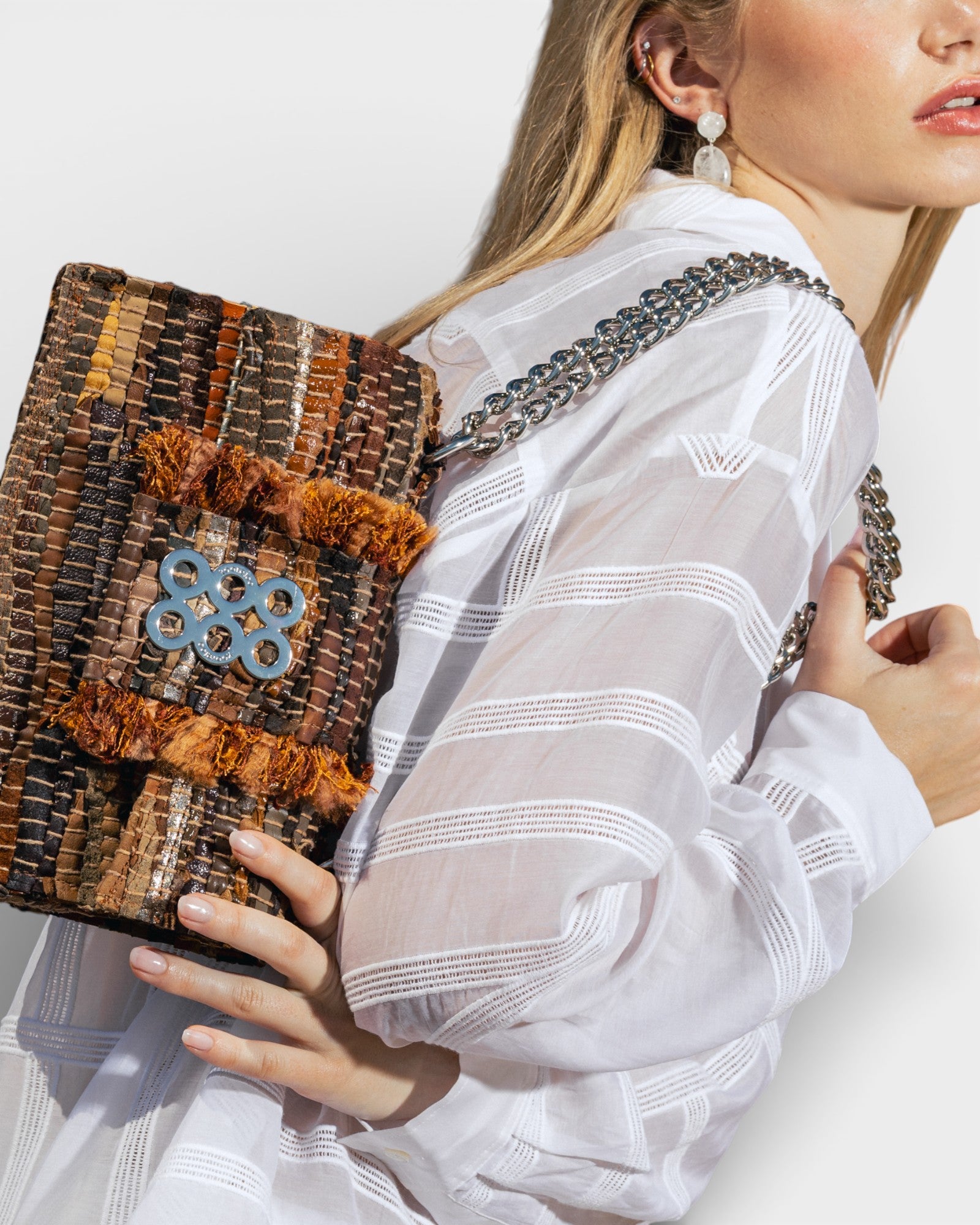 modelo con bolsoVista en ángulo del bolso Kooreloo New Yorker Soho mostrando la textura del cuero tejido y la cadena