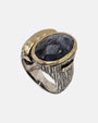 Anillo ancho artesanal con piedra azul ovalada en bisel dorado martillado y cuerpo de plata