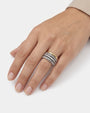 Anillo ancho de cuatro bandas con circonitas visto puesto en la mano de una modelo