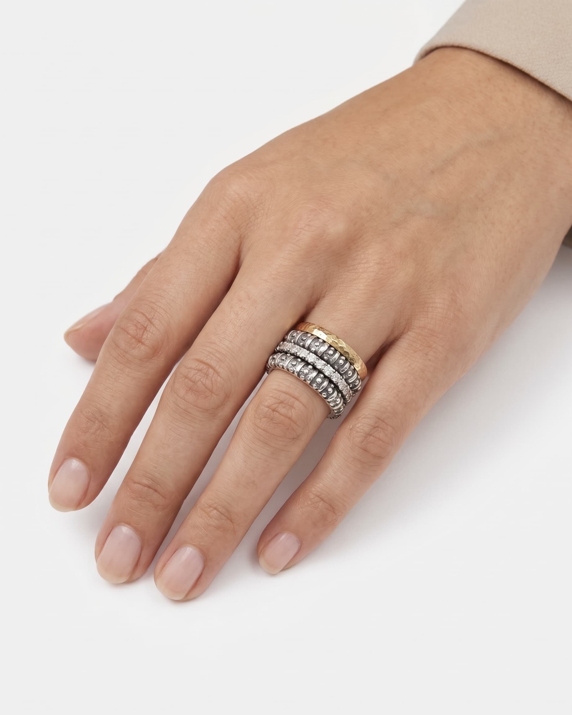 Anillo ancho de cuatro bandas con circonitas visto puesto en la mano de una modelo