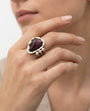 Anillo de diseño con piedra rubí zoicita visto puesto en la mano de una modelo