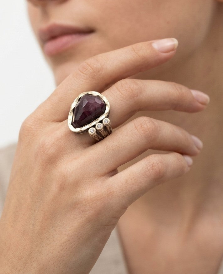 Anillo de diseño con piedra rubí zoicita visto puesto en la mano de una modelo