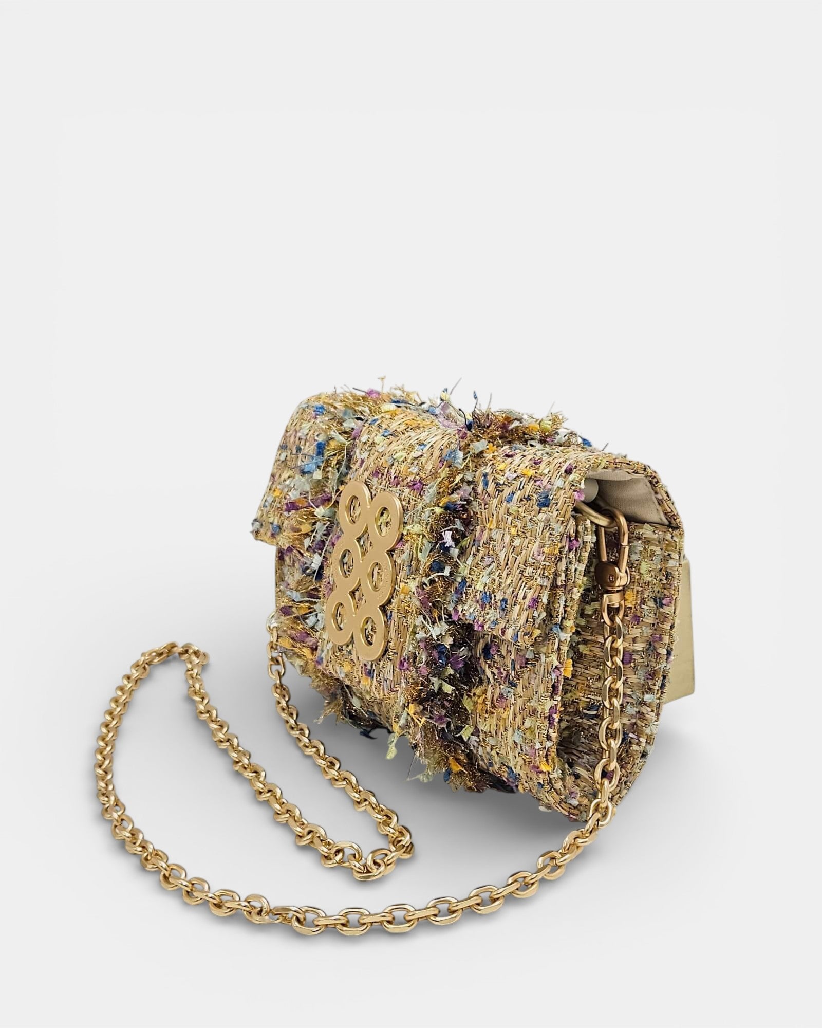 Vista lateral de bolso Kooreloo en tweed con cadena metálica dorada y forro interior claro.