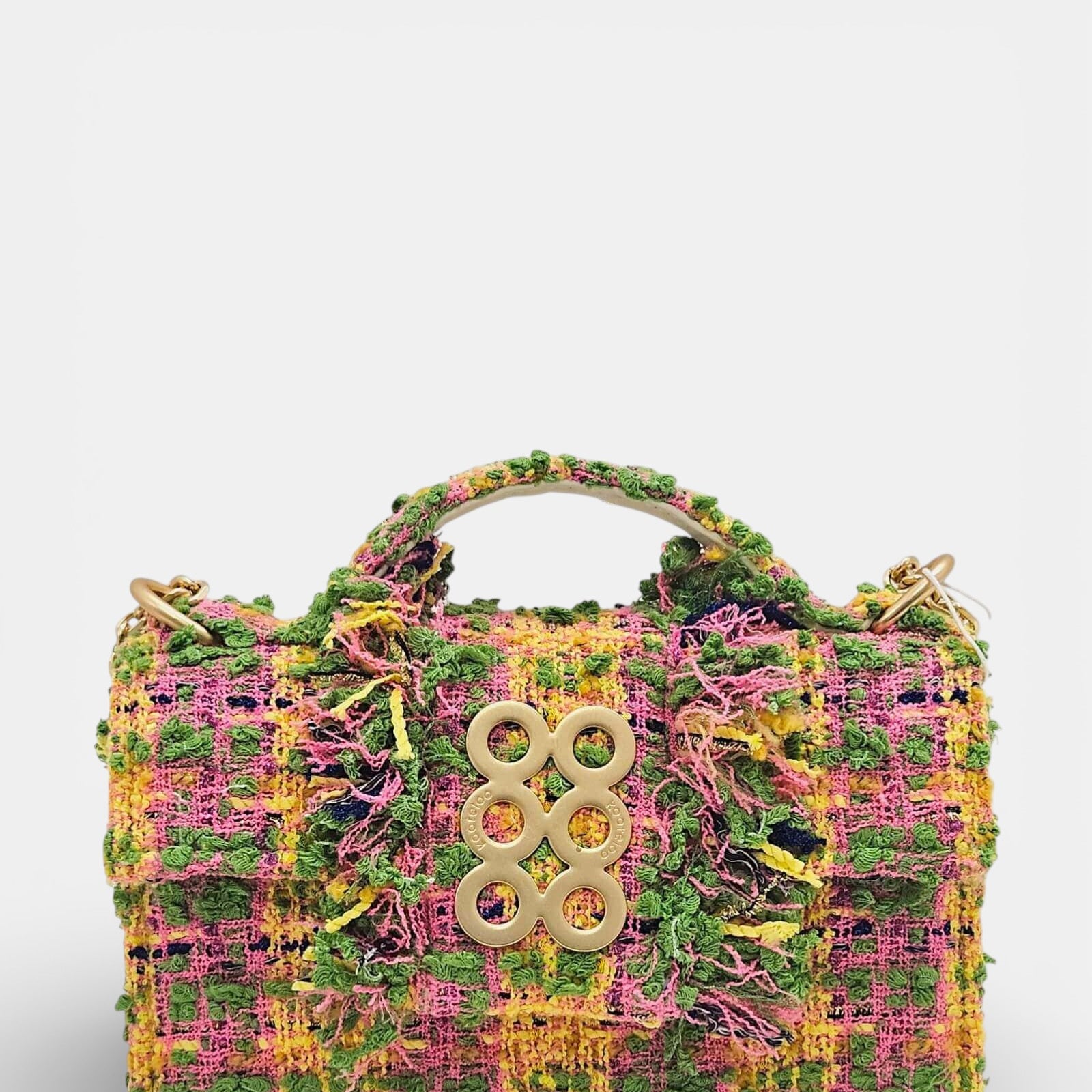 Vista frontal de bolso de mano Kooreloo confeccionado en tweed multicolor con detalles deshilachados y broche dorado de seis círculos.