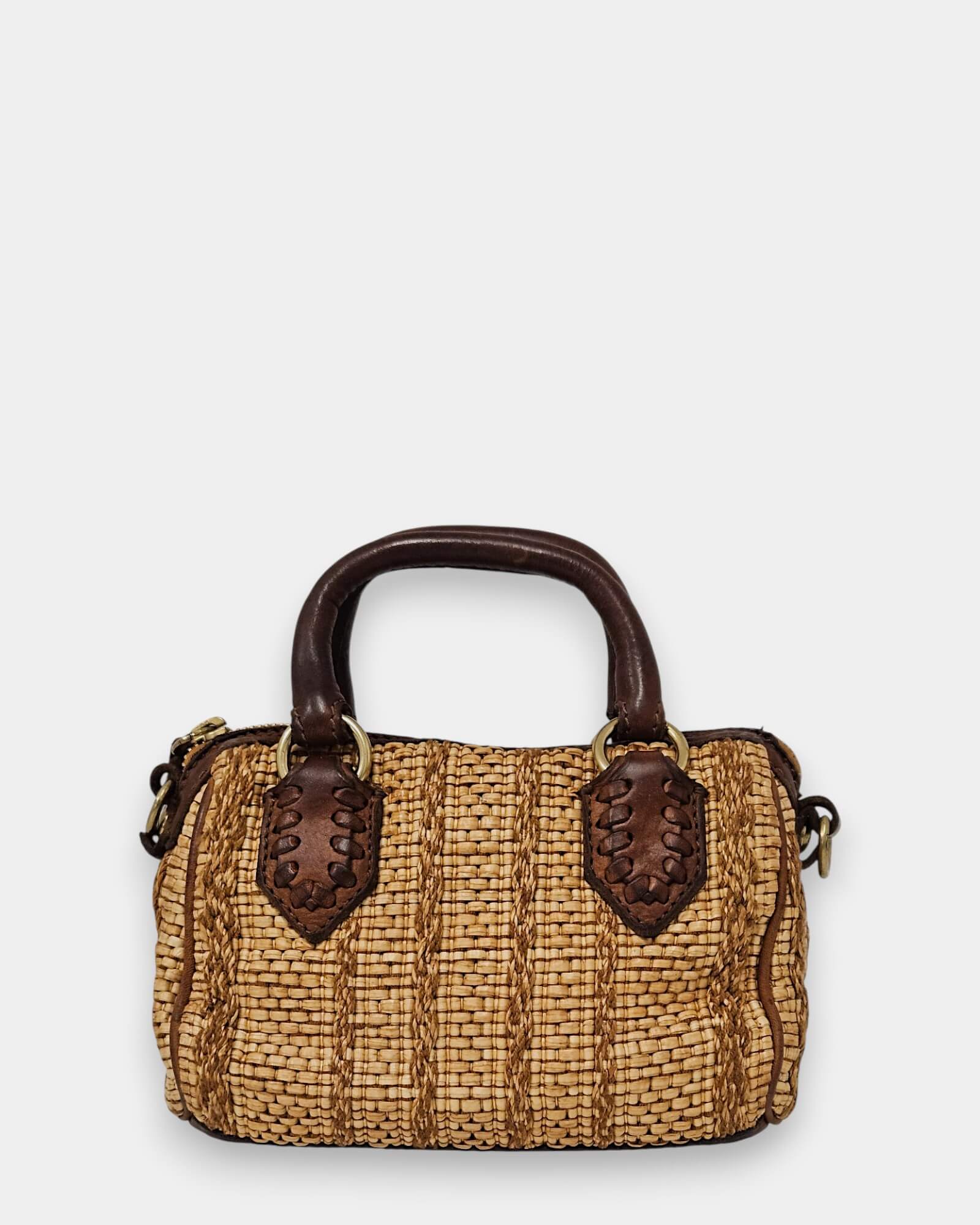 Bolso de mano Campomaggi de paja natural con asas y detalles de piel marrón, fondo blanco.
