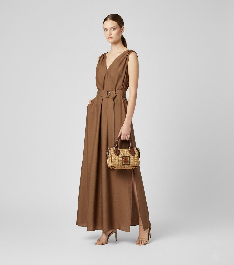 Mujer con vestido marrón largo y bolso mini Campomaggi de paja y piel, look Sanci elegante.