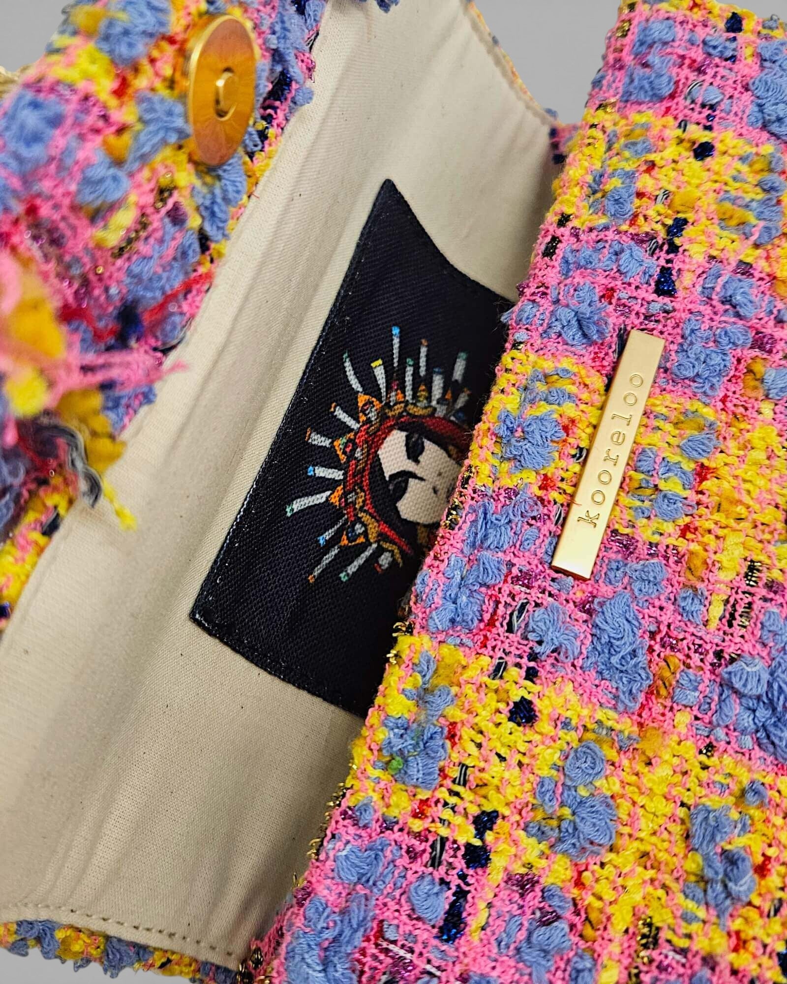 Forro interior de bolso Kooreloo con ilustración de arte tradicional griego y etiqueta de marca.