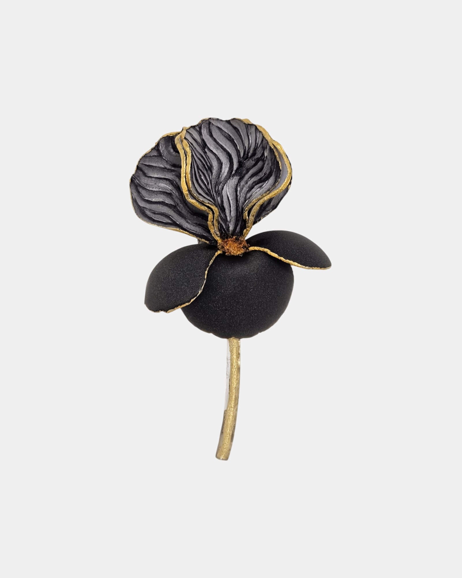 Broche floral de iris en color negro mate con detalles dorados y tallo metálico, joyería de autor Sanci.