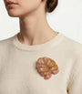 Mujer luciendo el broche statement Jamile Rosewood en la solapa de un mono de lino blanco, resaltando su volumen y elegancia parisina.