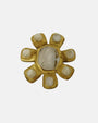 Broche Inna de Dominique Denaive con diseño radial en resina dorada e incrustaciones blancas efecto nácar.