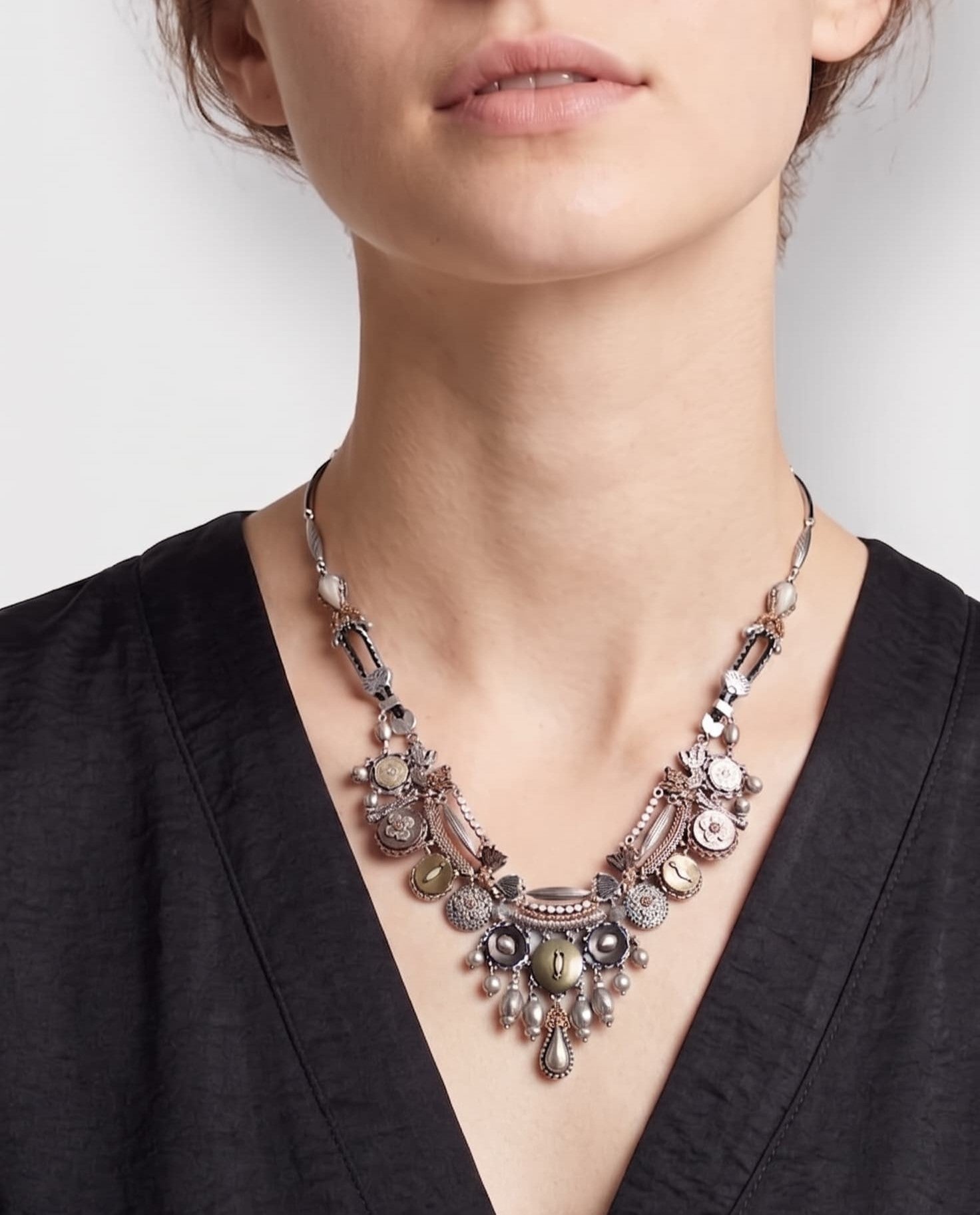 modelo con collar, permitiendo observar la disposición simétrica del motivo central y el diseño de la cadena metálica envejecida regulable.