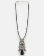 collar colgante completo, permitiendo observar la caída del motivo central y el diseño de la cadena metálica envejecida con cuentas decorativas intercaladas.