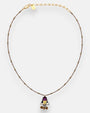 collar completo dispuesto de forma circular sobre fondo neutro, permitiendo observar los abalorios tubulares de la cadena y su alargador dorado con la chapa de la marca.