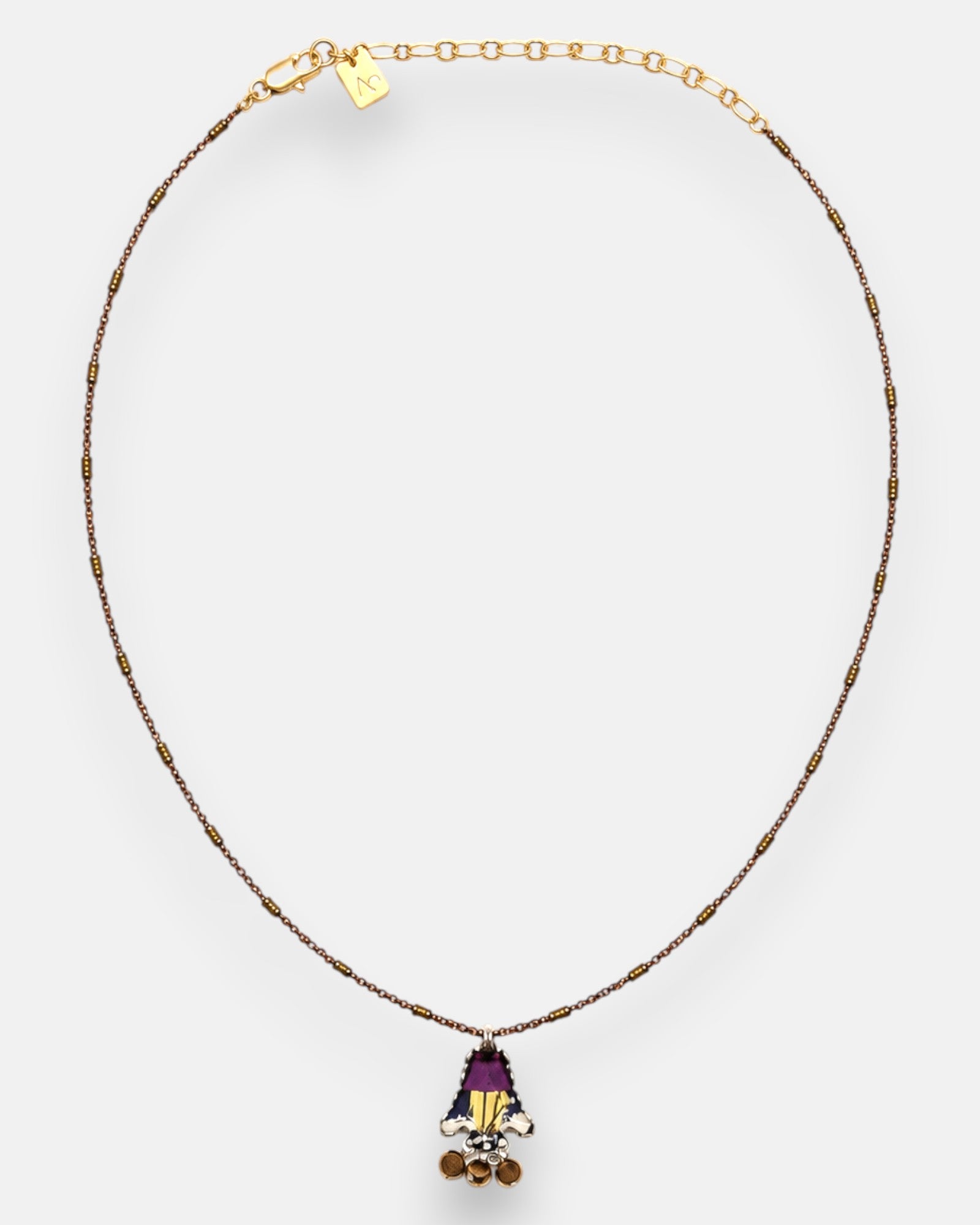 collar completo dispuesto de forma circular sobre fondo neutro, permitiendo observar los abalorios tubulares de la cadena y su alargador dorado con la chapa de la marca.