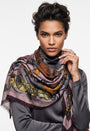 Modelo luciendo el foulard Faliero Sarti en modal y cashmere de estampado floral malva y mostaza sobre jersey gris.