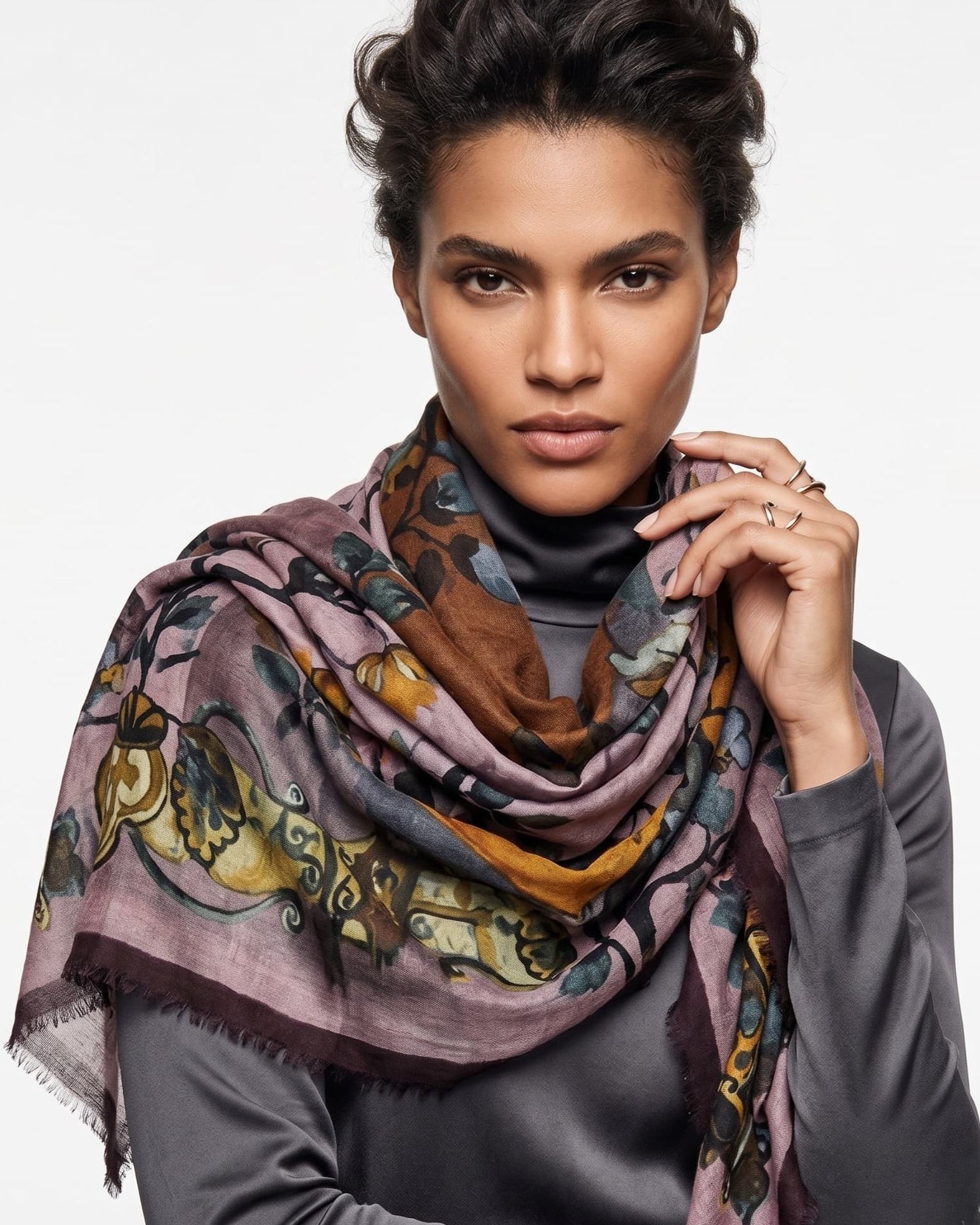Modelo luciendo el foulard Faliero Sarti en modal y cashmere de estampado floral malva y mostaza sobre jersey gris.