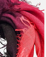 Primer plano del pliegue y textura esponjosa en cashmere y seda del foulard Faliero Sarti Loy mostrando la gradación de coral a negro.
