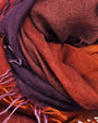 Primer plano en detalle de los pliegues y la textura afelpada en cashmere y seda del foulard Faliero Sarti Enrichetta en tonos berenjena y teja.