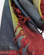 Primer plano en detalle de los flecos granate y la textura suave de lana y seda del foulard Faliero Sarti Ella.