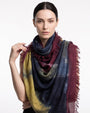 Modelo luciendo el foulard maxi de lana virgen y seda Faliero Sarti Ella doblado al cuello mostrando el frente azul y granate.