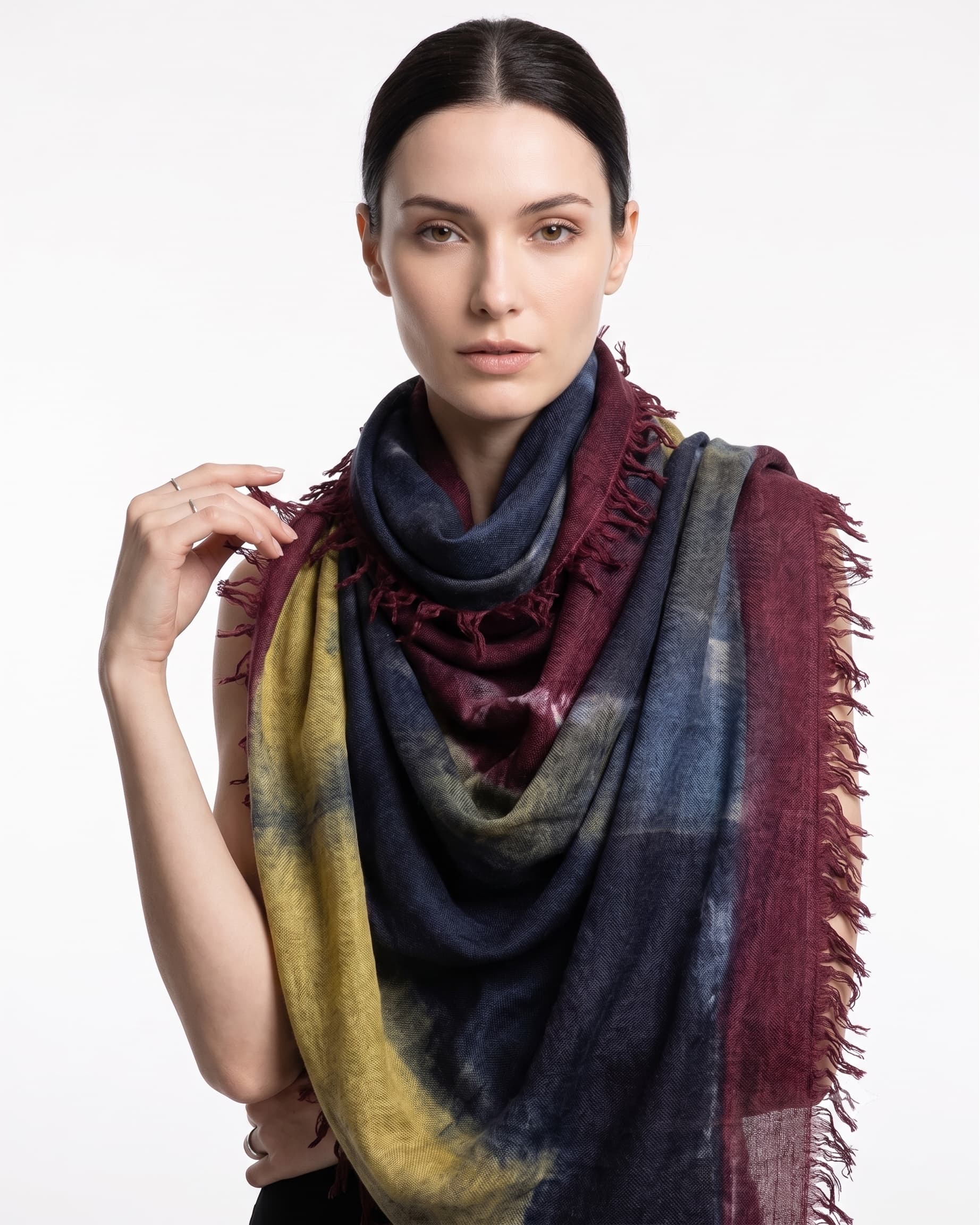 Modelo luciendo el foulard maxi de lana virgen y seda Faliero Sarti Ella doblado al cuello mostrando el frente azul y granate.
