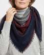 Modelo luciendo el foulard Faliero Sarti Little Giudy doblado en triángulo al cuello sobre un jersey de punto gris.
