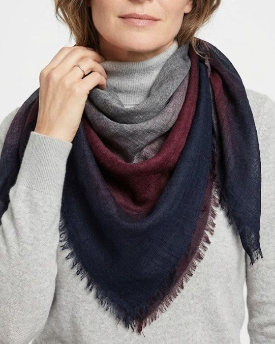 Modelo luciendo el foulard Faliero Sarti Little Giudy doblado en triángulo al cuello sobre un jersey de punto gris.