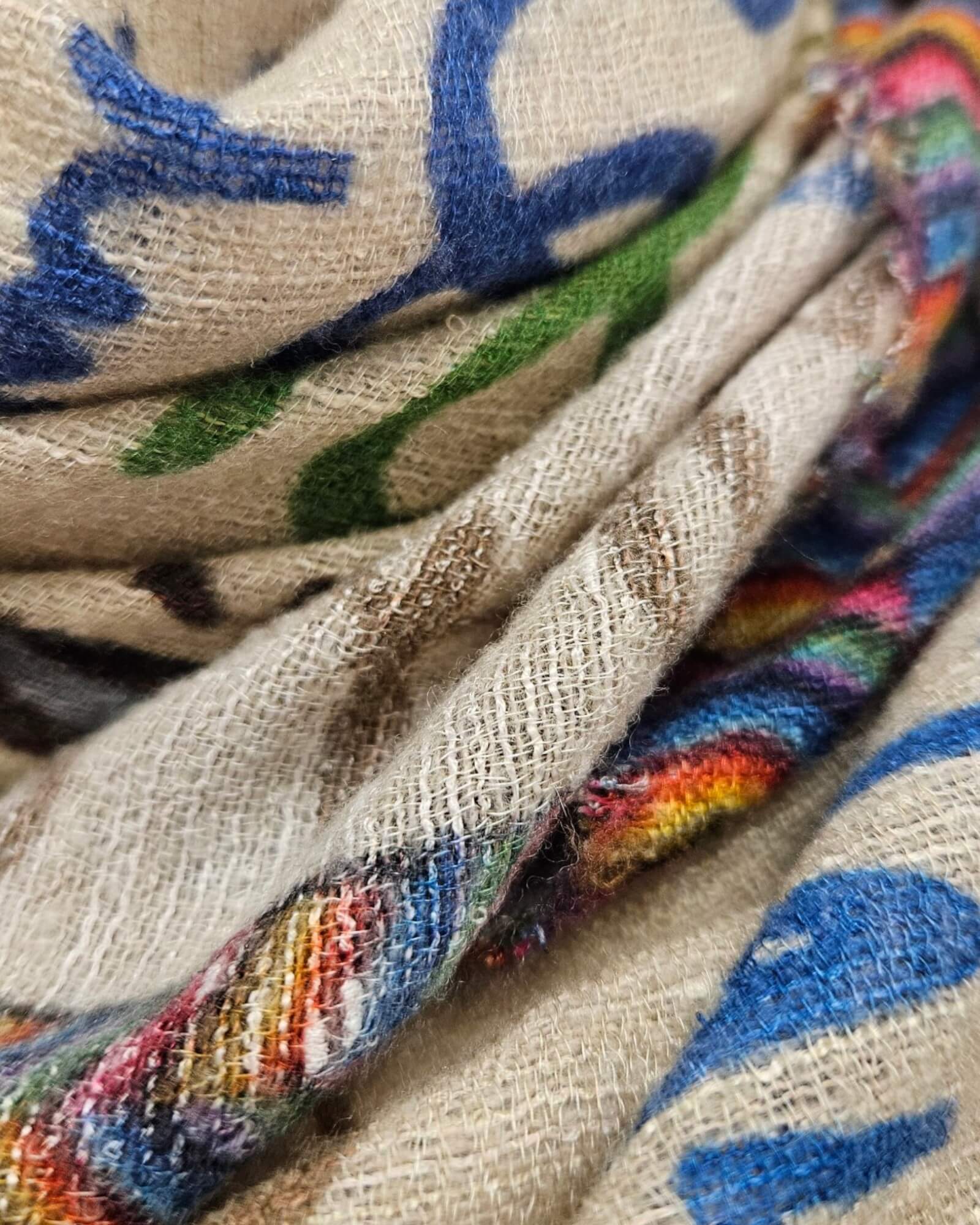 Primer plano en detalle del entramado de seda y cashmere del foulard Faliero Sarti mostrando los trazos azules y la cenefa multicolor.