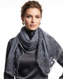 Modelo luciendo el foulard Faliero Sarti Fiorenza en lana azulado con bordes de encaje bordado sobre jersey gris.