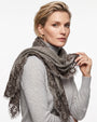 Modelo luciendo el foulard Faliero Sarti Fiorenza en lana gris con bordes de encaje bordado sobre jersey claro.