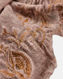 Primer plano en detalle del relieve del bordado dorado y la textura fina de lana del foulard Faliero Sarti Fiorenza.