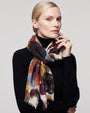 Modelo luciendo el foulard de cashmere Faliero Sarti anudado al cuello sobre un jersey negro de cuello alto.