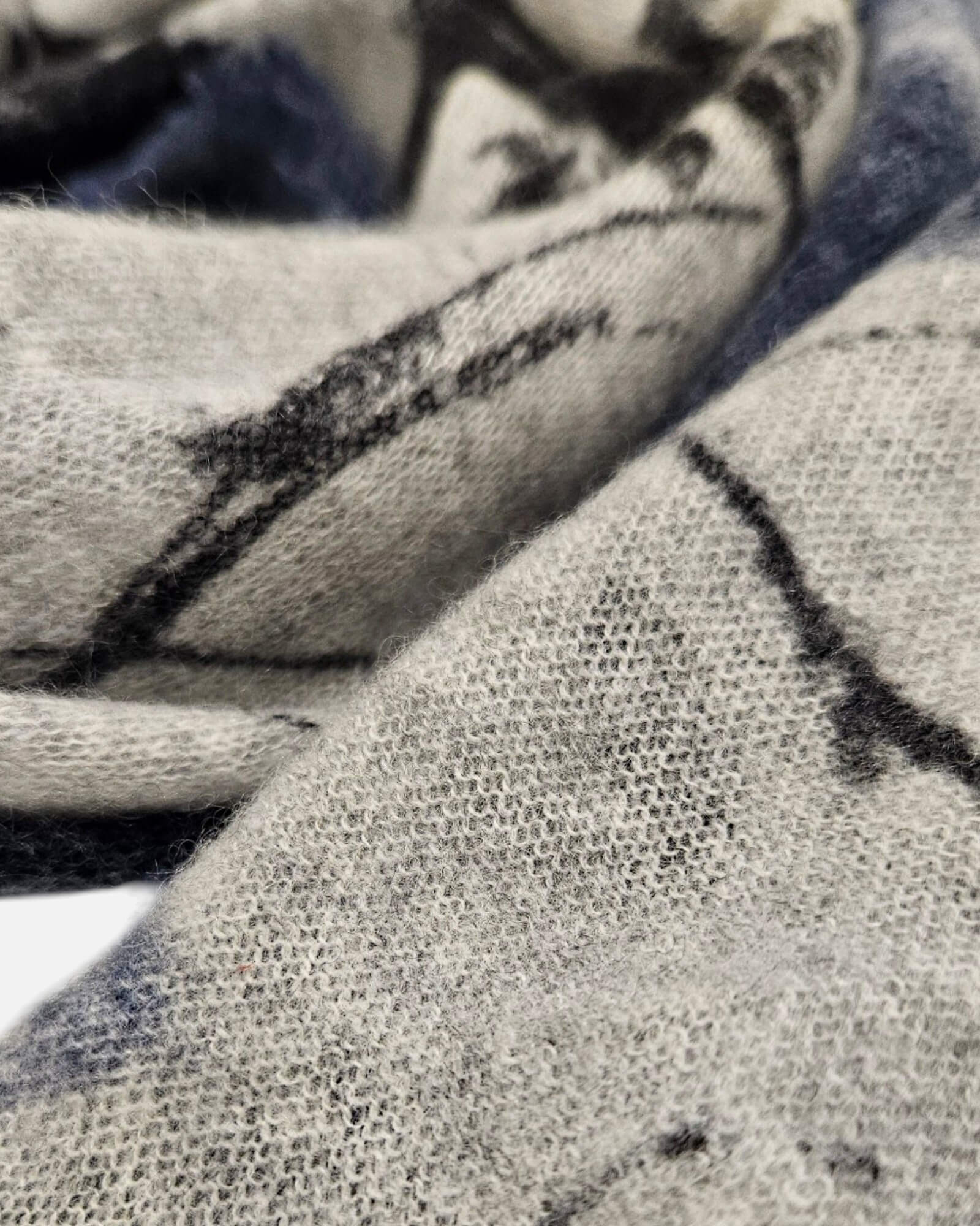 Primer plano de la trama de pure cashmere del foulard Faliero Sarti Pia mostrando la textura en tono gris melange y trazos negros.