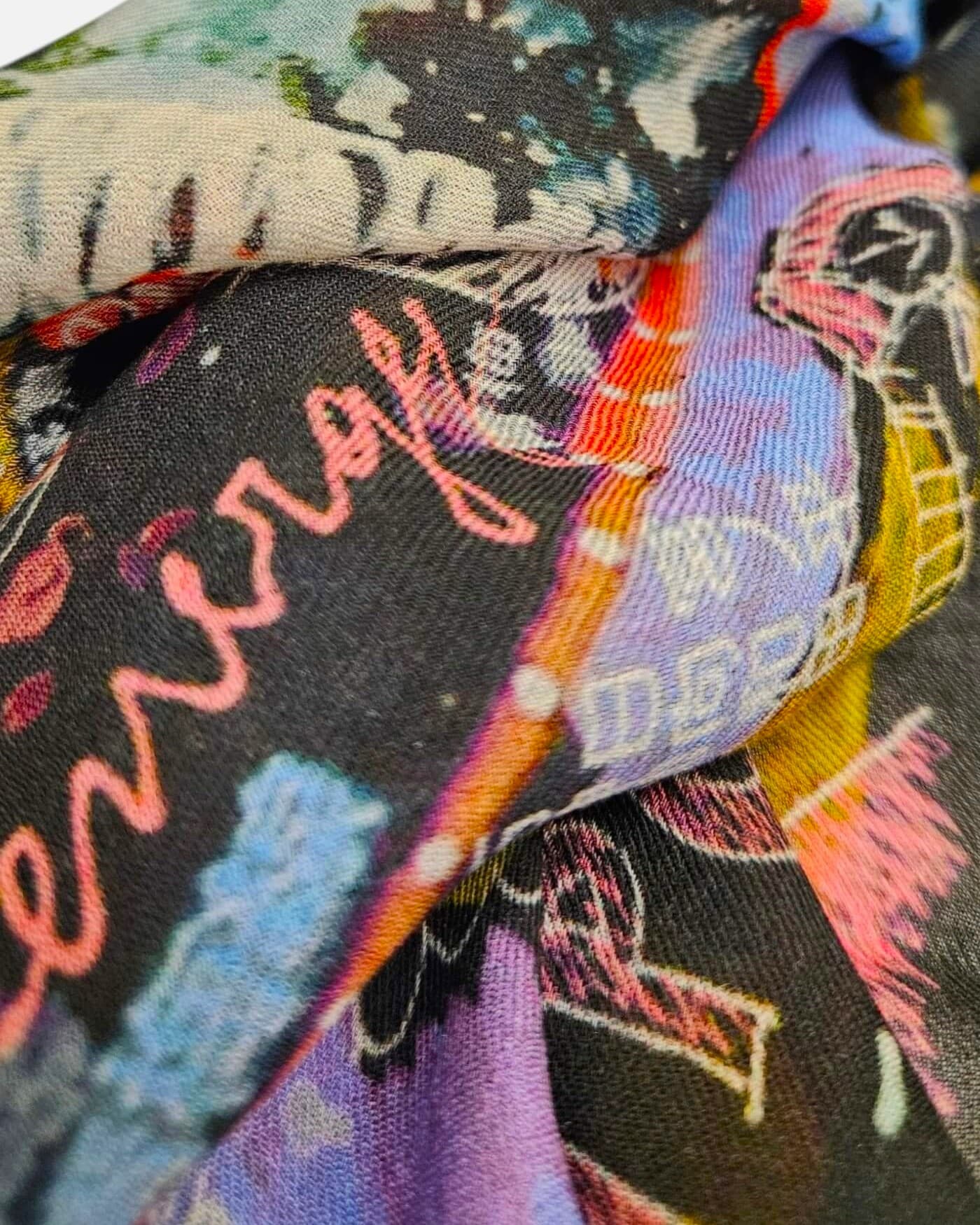 Detalle del tejido de modal y cashmere del foulard Faliero Sarti Tokyo con tipografía rosa y azul.