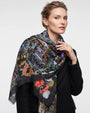 Modelo vistiendo el foulard Faliero Sarti Tokyo en modal y cashmere drapeado sobre la espalda con abrigo negro.