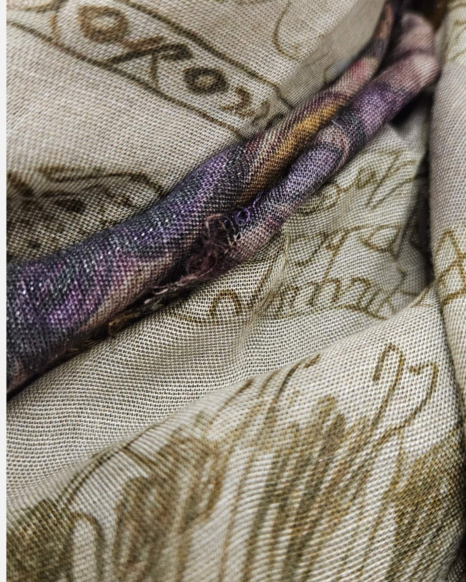 Primer plano en detalle del tejido satinado de rayón, modal y cashmere con sutiles destellos metálicos del pañuelo Faliero Sarti.