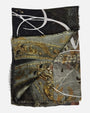 Vista doblada del foulard Faliero Sarti Elisabetta mostrando la cenefa de flores en oro y el contraste geométrico.