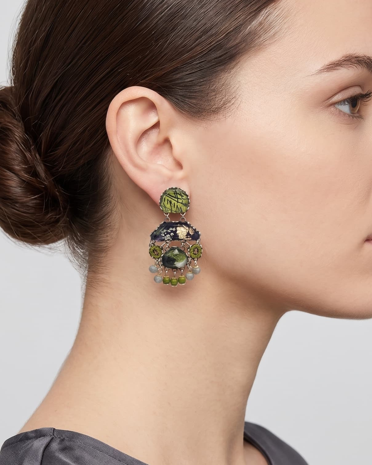 modelo de perfil luciendo uno de los pendientes colgantes de Ayala Bar, apreciando cómo asienta la pieza y su escala equilibrada con respecto al rostro.