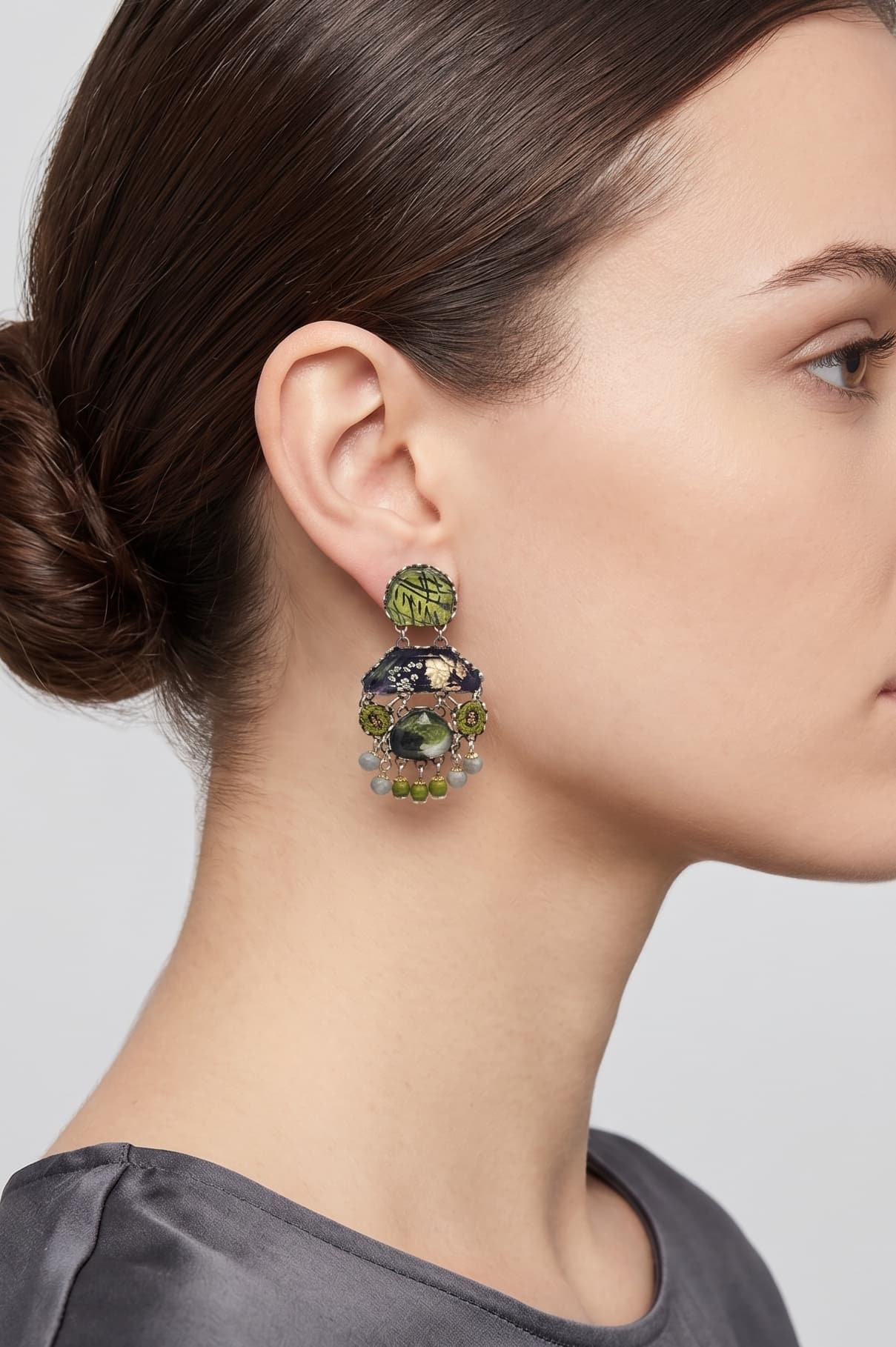 modelo de perfil luciendo uno de los pendientes colgantes de Ayala Bar, apreciando cómo asienta la pieza y su escala equilibrada con respecto al rostro.