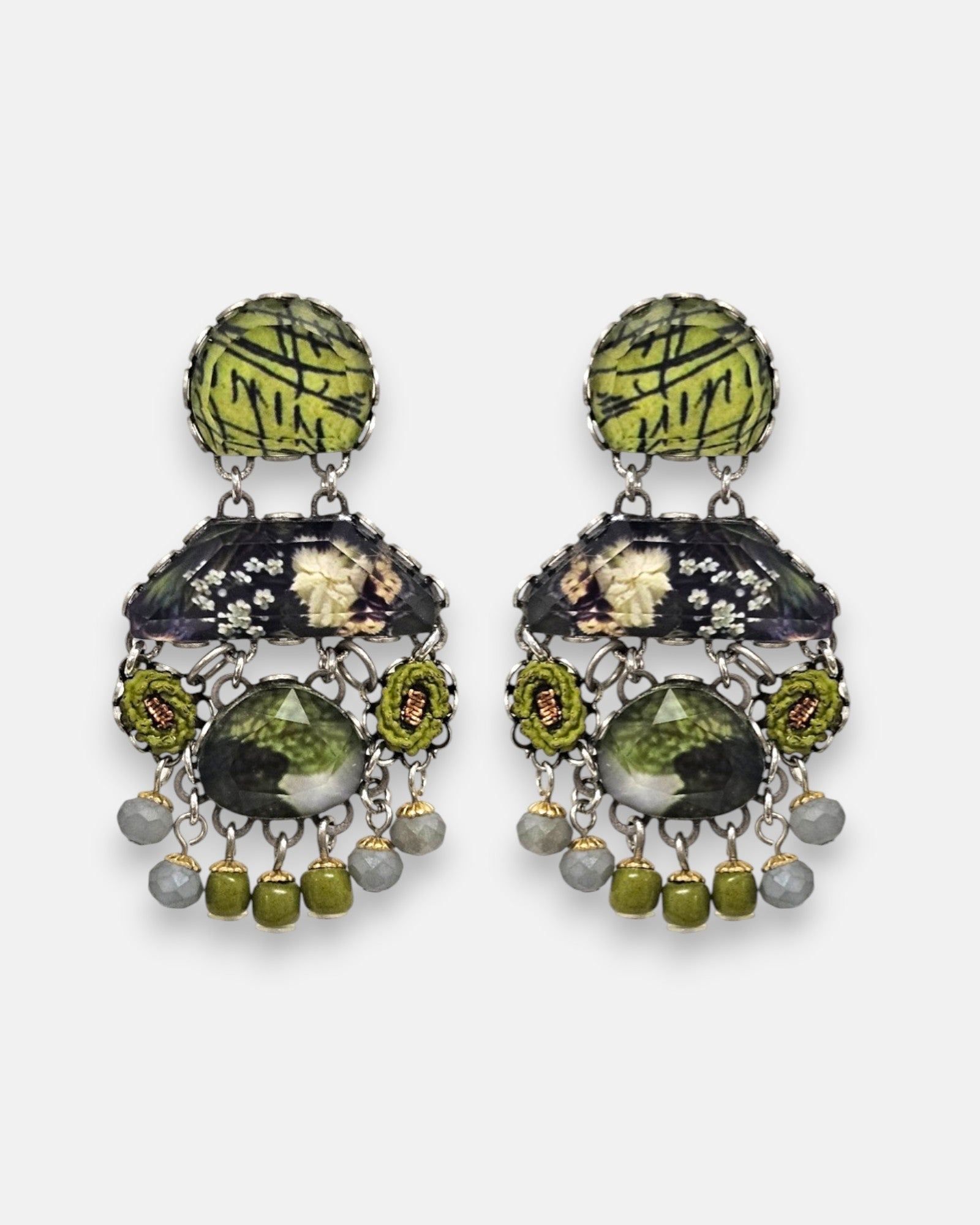 pendientes expuesto de frente sobre un fondo gris claro, detallando su silueta simétrica de estilo bohemio con cabujones verdes y grises.