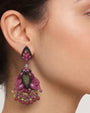 Pendientes largos de invitada Dublos buganvilla y morado vistos puestos con peinado recogido