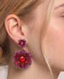 Pendientes florales de fiesta Dublos en tono rojo y fucsia vistos puestos en modelo