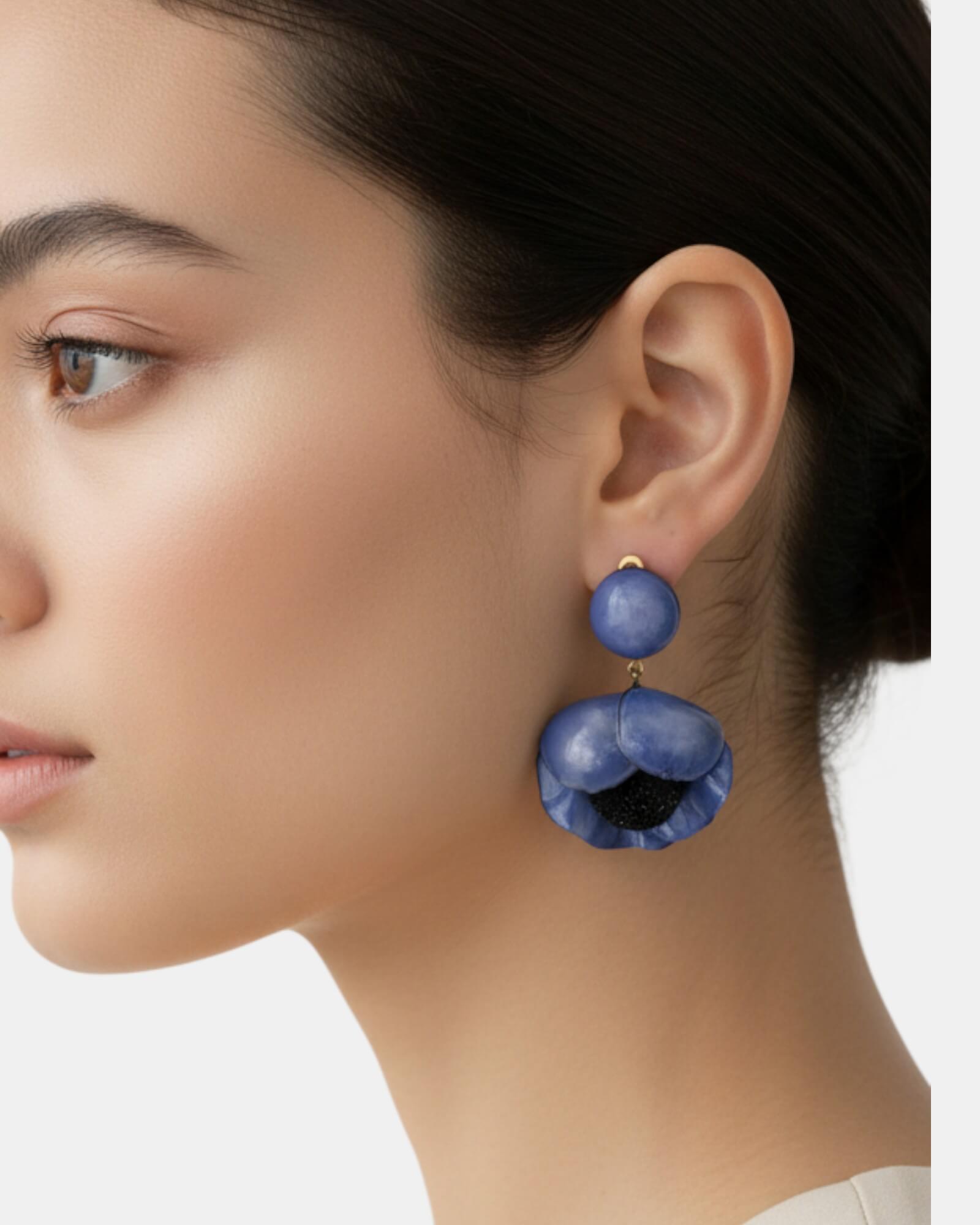 Pendientes flor azul Sanci en modelo, fondo claro, joyería elegante mujer