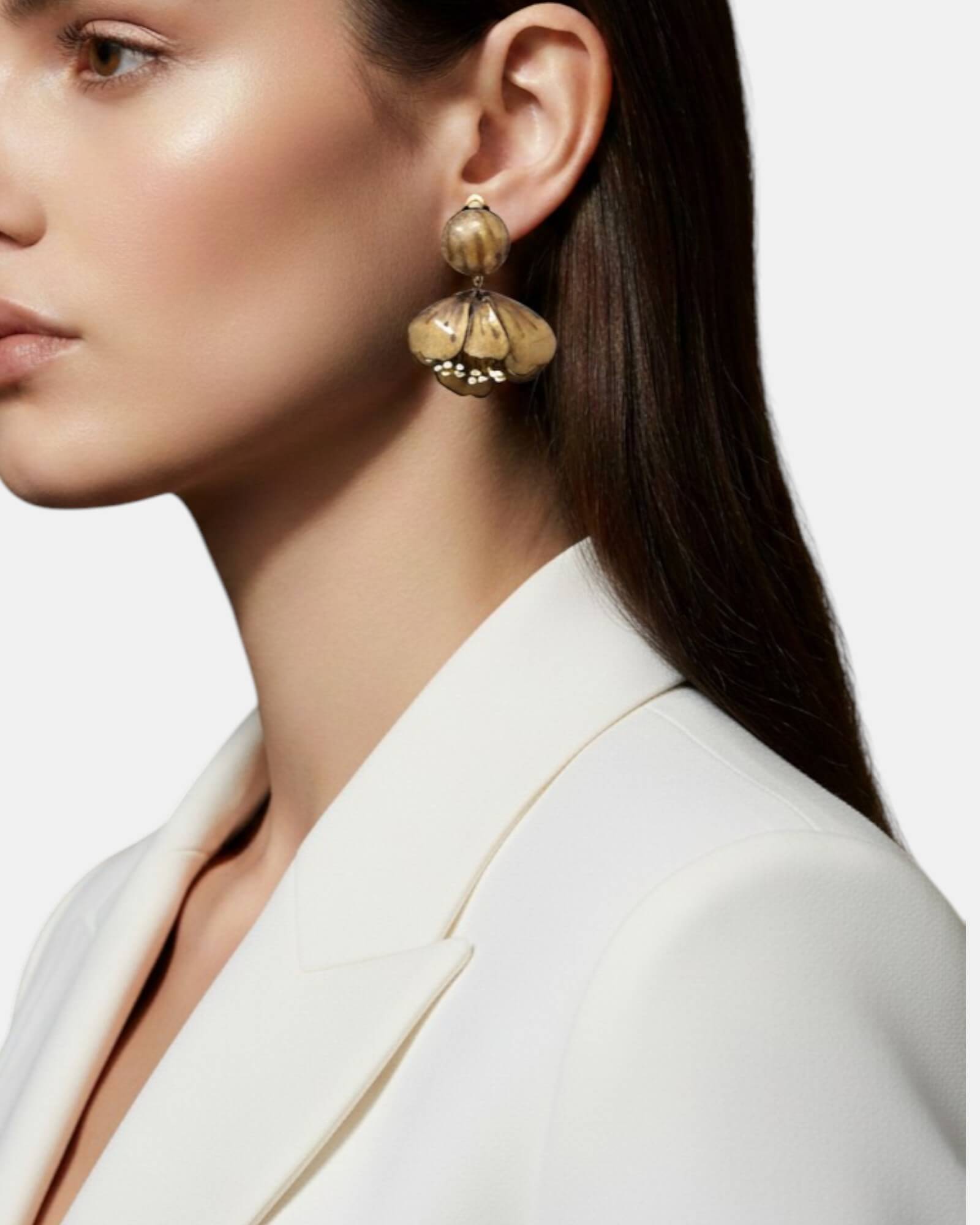 Mujer con pendientes maxi flor dorada envejecida, look elegante Sanci