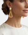 Perfil de modelo luciendo los pendientes Gervaise Rosewood, resaltando su tamaño statement y elegancia contemporánea con un recogido bajo.