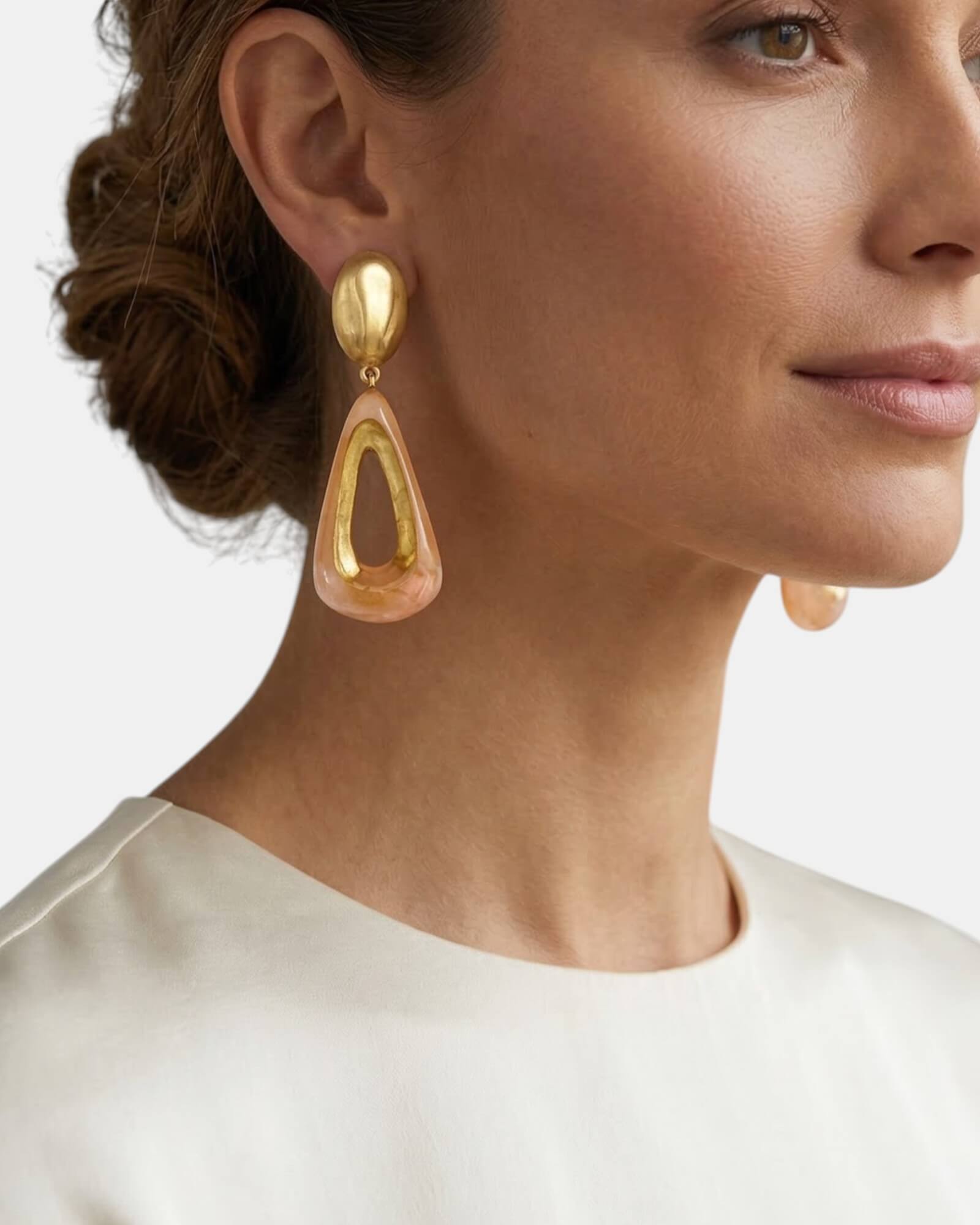 Perfil de modelo luciendo los pendientes Gervaise Rosewood, resaltando su tamaño statement y elegancia contemporánea con un recogido bajo.
