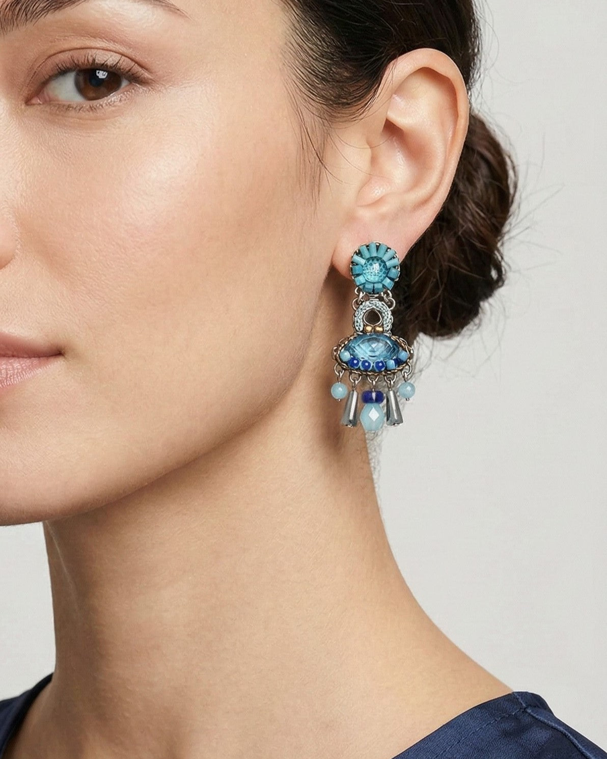 Mujer luciendo los pendientes Horizon de Ayala Bar en tonos azules con un recogido elegante.
